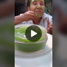 a man with green facial mask on sitting at a table in front of a bowl