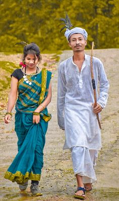 a man and woman walking down a dirt road