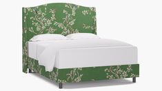 a bed with green upholstered headboard and white sheets