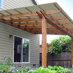 an outdoor patio covered with wooden pergols and plants in front of a house