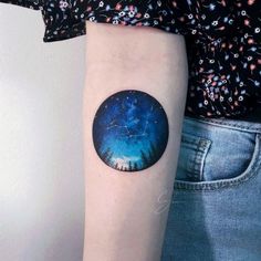 a person with a tattoo on their arm has a blue sky and stars in the background