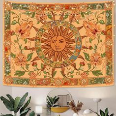 a tapestry hanging on the wall in a room with potted plants and other decorations