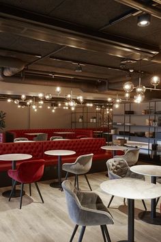 an empty restaurant with red and grey chairs