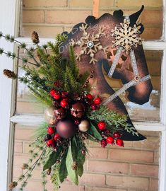 a horse head decorated with christmas decorations and greenery hangs on a brick wall in front of a window