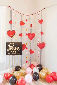 balloons and streamers in the shape of hearts are on display at a valentine's day party