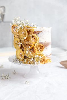 a white cake with orange slices and baby's breath on top