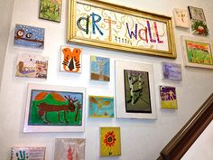 the wall is covered with many different paintings and pictures, including children's artwork