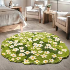 a green rug with white daisies in the center on a wooden floor next to a bed