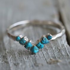 a silver ring with three turquoise stones on it