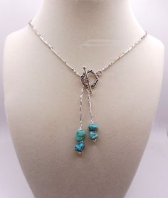 BEAUTIFUL silver beaded turquoise lariat necklace. The silver beads are twisted silver plated bugle beads; each are 5 mm long. The beads are strung and resemble a unique chain, though this is not a chain. The decorative antique silver toggle lays in front. Genuine turquoise nuggets are strung and attached to the toggle bar. Silver spacer beads separate the turquoise nuggets. This one of a kind necklace was of my creation. Know that when you are wearing this necklace, nobody else will have this necklace!  Please note: This necklace is not adjustable.  The necklace is 20 1/2" long. Check out my other fine designs at: etsy.com/shop/hubbardsdesigns Elegant Adjustable Turquoise Lariat Necklace, Elegant Adjustable Lariat Turquoise Necklace, Adjustable Beaded Lariat Turquoise Necklace, Adjustable Beaded Turquoise Lariat Necklace, Lariat Necklaces With Polished Beads For Jewelry Making, Silver Wire Wrapped Lariat Necklaces, Blue Sterling Silver Lariat Necklace, Turquoise Beaded Dangle Lariat Necklace, Adjustable Silver Wire Wrapped Lariat Necklace