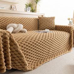 a couch covered with a blanket and pillows