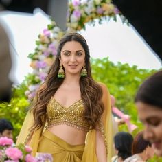 a woman in a yellow sari and matching earrings