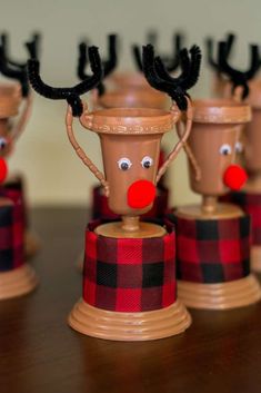 some brown cups with reindeer noses and nose decorations on top of each other, sitting on a table