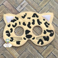 a leopard mask with black and white spots on the face, sitting on a wooden floor