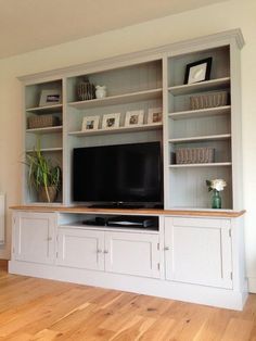 an entertainment center with built in cabinets and a flat screen tv