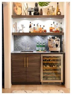 a kitchen with shelves filled with bottles and glasses on top of the counter, next to a wine refrigerator