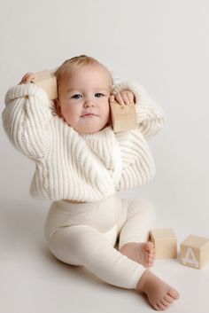 a baby is sitting on the floor with blocks