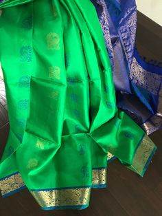 This is a beautiful subtle parrot green Kanjivaram pure silk saree with royal blue border pallu. Saree has a double side border with peacock and floral zari motifs. Pallu also thread motifs.Body has peacock motifs in alternating blue silk thread and zari. Saree is finished with tassels. Saree comes with an unstitched blouse piece in royal blue ( Last picture) Colour may vary slightly due to lighting  *No falls or pico done *Dr clean only *All sales are final  * Colour may vary slightly due to li Tassels Saree, Saree Green, Kanjeevaram Silk Saree, Peacock Motifs, Zari Saree, Blue Silk Saree, Side Border, Side Borders, Parrot Green