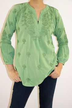 Immerse yourself in the charm of the Cassie Blouse, crafted from pure cotton in a mesmerizing array of variegated hues. Hand-embroidered with vintage chikankari in self, this blouse boasts an artful elegance. With a split open neckline and raglan sleeves featuring extended shirred extensions, it offers a timeless silhouette. The rounded hem adds a gentle touch, making it perfect to pair with your favorite jeans or skirt for an effortlessly chic look. Length: 27-29 inches. Sizes -  S - fits bust 34 M - fits bust 36 L - fits bust 38 XL - fits bust 40 0X - fits bust 42 Prewashed. Preshrunk. Wash Independantly in cold water. Line Dry. Light iron for best results. Cotton Tunic, Blouse Price, Gentle Touch, Cotton Blouse, Cotton Blouses, Favorite Jeans, Raglan Sleeve, Womens Clothing Tops, Hand Embroidered