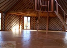 the inside of a yurt with wooden floors and walls that have been built into it