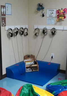 a room with several different types of headphones on the wall and inflatable mattresses