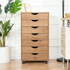 a wooden dresser sitting next to a potted plant on top of a hard wood floor