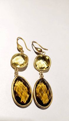 These vintage earrings are quite stunning and just what you need for special occasions. They feature faceted round and teardrop shaped smoky and yellow quartz in gold settings that catch the light just perfectly. They dangle from gold-toned ear wires. From the top of the wire to the bottom of the pearl, they measure 3 inches. These earrings are in very good vintage condition. Thanks for visiting my vintage jewelry store! Back to my shop here: https://www.etsy.com/shop/RemembrancesofYours Elegant Gold Teardrop Earrings With Gemstone, Gold Faceted Earrings For Anniversary, Elegant Gold Citrine Earrings, Gold Faceted Drop Earrings, Gold Gemstone Teardrop Earrings For Formal Occasions, Gold Faceted Citrine Earrings, Gold Teardrop Earrings With Gemstone For Anniversary, Gold Citrine Faceted Earrings, Elegant Yellow Faceted Earrings