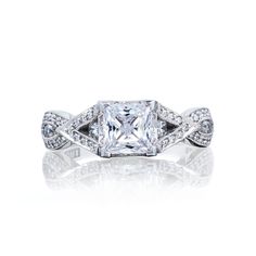 an engagement ring with a princess cut diamond in the center and pave set shoulders