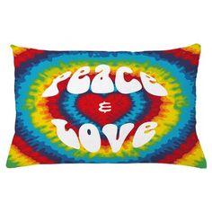 a pillow with the words peace and love in white letters on a multicolored tie dye background