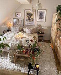 a bed room with a neatly made bed and lots of pictures on the wall above it