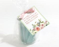 a blue vase with a pink bow on it and a card attached to the top