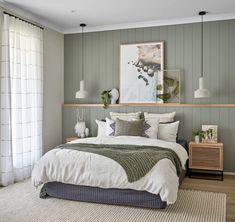 a large bed sitting in a bedroom next to a wooden dresser and window with white curtains