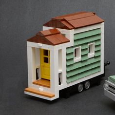 a toy truck with a tiny house on the front and small windows in the back