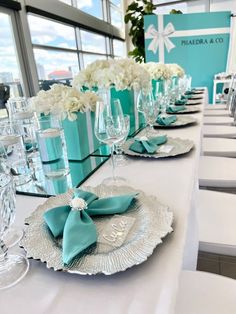 the table is set with white flowers and blue napkins