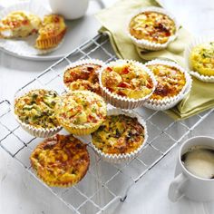 several muffins on a cooling rack next to a cup of coffee