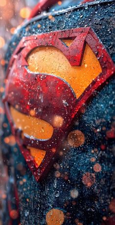 the superman symbol is seen in this close up photo, with rain falling on it