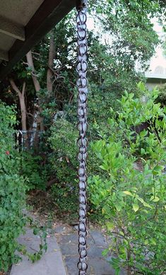 a black and white pole sitting in the middle of a yard next to trees, bushes and shrubbery