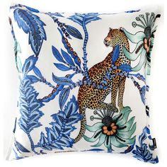 a blue and white pillow with a leopard on it's back, surrounded by leaves