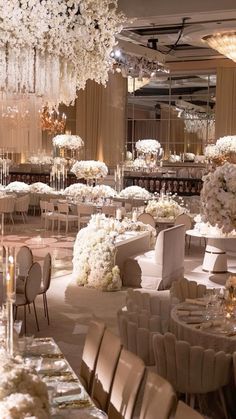 an elegant wedding reception with white flowers and chandeliers