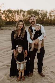 a man, woman and child are standing in the sand with their arms around each other