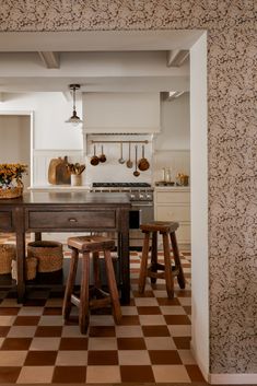 a kitchen with checkered flooring and wooden stools