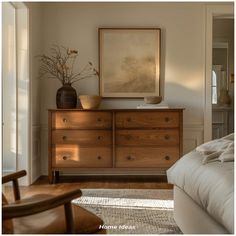 a bedroom with a bed, dresser and painting on the wall