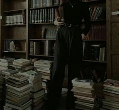 a woman is standing in front of a bookcase full of books and looking at the camera