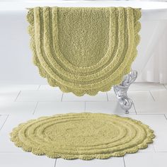 two rugs on the floor in front of a bathtub