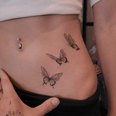 a woman's stomach with three butterflies on it and the bottom part of her belly