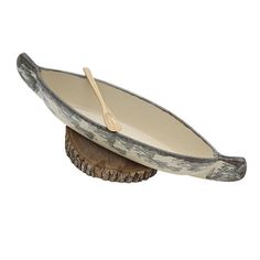 a wooden bowl with a spoon in it on top of a piece of tree stump