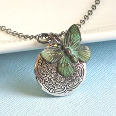 Small Silver Locket Necklace - Decorative Small Silver Ox Locket accented with a Verdigris Brass Butterfly. The Locket is 20 mm (slightly smaller than US nickel) and has a floral pattern. Stainless Steel Chain The patina on the butterfly will vary slightly from the one pictured. For other locket designs: http://www.etsy.com/shop/mcstoneworks/search?search_query=locket&search_submit=&search_type=user_shop_ttt_id_5402200&shopname=mcstoneworks Green Charms Jewelry Perfect For Gifts, Whimsical Green Jewelry With Charms, Whimsical Green Charms Jewelry, Silver Butterfly Necklace For Birthday, Green Wedding Locket Necklace, Green Vintage Charm Pendant Jewelry, Green Pendant Jewelry With Vintage Charm, Green Vintage Charm Jewelry For Gift, Green Vintage Charm Jewelry Gift