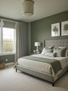 a bedroom with green walls and white bedding, two pictures on the wall above the bed