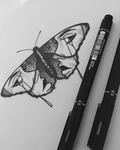 a drawing of a butterfly on paper next to a black marker with the words, i love you