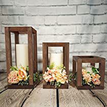 three wooden frames with flowers and candles in them